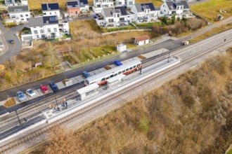Small train stops at a railway stop within a residential development, historic event, first test