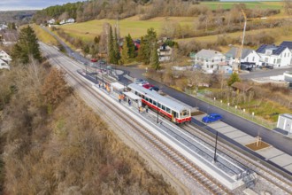 Small train on the platform in a rural area with houses and trees, historic event, first test run