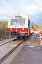Train travels on rails through a landscape, past the railway signal, with cloudy sky, historic