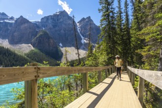 Female tourist walking on the rockpile trail admiring the turquoise color and the majestic