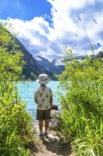 Young tourist admiring the stunning turquoise waters of lake louise, framed by victoria glacier and