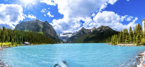Panoramic view of tourists canoeing on turquoise lake louise, featuring the iconic fairmont chateau