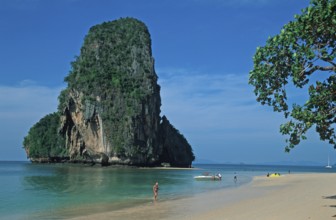 Rocks in the sea, tree, boat and people on Pranang Cave beach, two years in front of the tsunami,