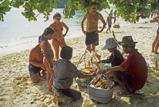 Woman with food store and customers on Pranang Cave beach, two years in front of the tsunami,
