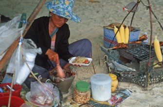 Woman with food stash on Pranang Cave beach, two years in front of the tsunami, Krabi, Thailand,