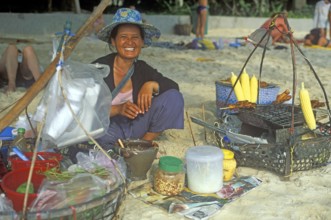 Woman with food stash on Pranang Cave beach laughing at the camera, two years in front of the