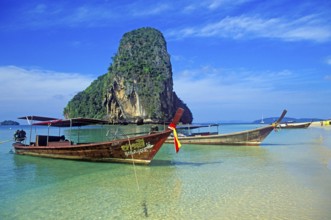 Rocks in the sea and longtail boats on Pranang Cave beach, two years in front of the tsunami,