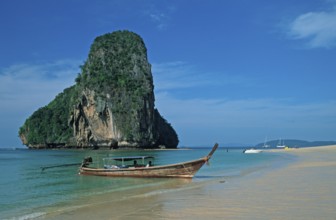 Rocks in the sea and longtail boat on Pranang Cave beach, two years in front of the tsunami, Krabi,