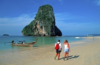 People, rocks in the sea and longtail boat on Pranang Cave beach, two years in front of the