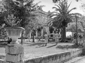 Two women standing in garden of Baroque style classical building at unknown location in Malta,