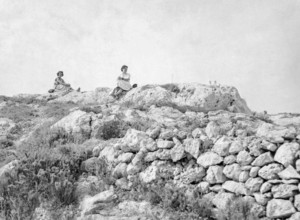 Two woman sitting on rocks in rural area Malta, Europe, 1956