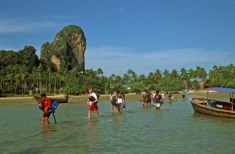 Tourists wade to their boat taxi that brings them back to Krabi, two years in front of the tsunami,