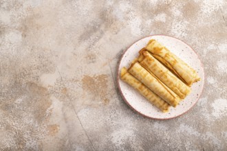 Waffles with caramel on brown concrete background, top view, flat lay, copy space