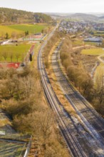 Rails and roads in a rural area with an adjacent village, construction of the Hermann Hesse