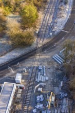 Construction site on a railway line with building materials next to a road, construction of the