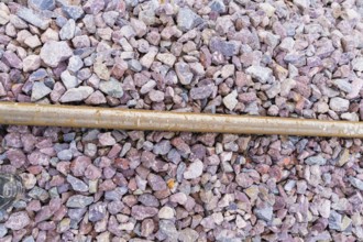 Close-up of gravel on railroad tracks with a metal rod as a contrast, construction of the Hermann