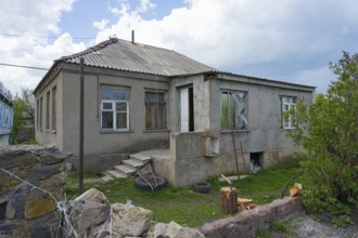 Abandoned house with damaged windows and brick walls in a rural area, inhabited house, Sameba,