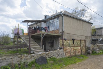 Rural building with external staircase, suspended clothing and adjacent wall, inhabited house,