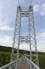 Close-up of the steel structure of a modern suspension bridge against a blue sky, Diamond Glass