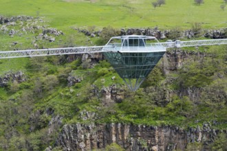 A glass bridge floats over a rocky and green gorge, Diamond Glass Bridge, world's longest