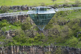 Modern glass bridge crosses green gorge with trees and rocks, diamond bridge, Diamond Glass Bridge,