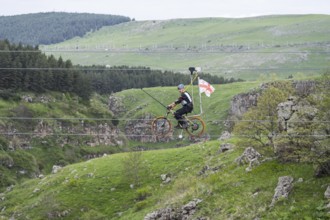 Cycling on a stretched rope across a hilly landscape with trees, Dashbashi Gorge, Khrami River,