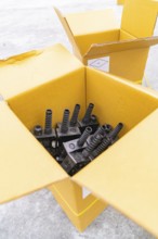 Open boxes with black charging stations inside, parking garage construction with charging