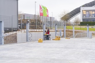 Two men sitting outdoors at a table on a construction site, parking garage construction with