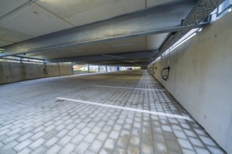 Empty covered parking lot with concrete structure and marked parking spaces, parking garage
