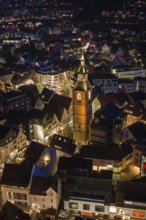 Night view of an illuminated city landscape with a central church in a wintery setting,