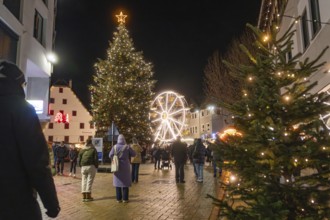 Illuminated Christmas tree and Ferris wheel in a festively decorated city at night, Weihnachtsmark