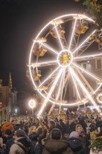 Large illuminated Ferris wheel surrounded by crowds at a Christmas market, Weihnachtsmark Nagold,