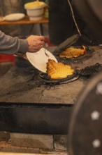 A person picks waffles baked fresh at a market from an oven, Weihnachtsmark Nagold, LandkreiScalw,
