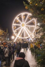 Illuminated Ferris wheel with people at a Christmas market in a festive atmosphere, Weihnachtsmark