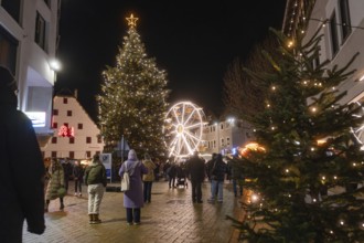 Night view at a Christmas market with illuminated tree and Ferris wheel, Weihnachtsmark Nagold,