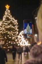 An illuminated tree at a Christmas market is captured with a smartphone, Weihnachtsmark Nagold,
