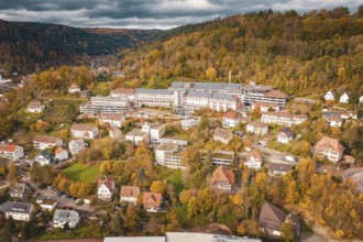 City view in autumn landscape with hills, buildings and cloudy sky, Old Hospital, Calw, Germany