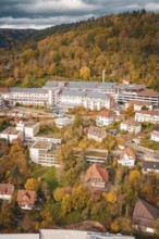 Autumn city view with buildings and trees in hilly landscape under cloudy sky, Altes Krankenhaus,