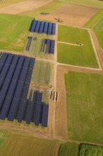 Bird's-eye view of solar panels on green fields in a rural area, Energiewende, construction of PV