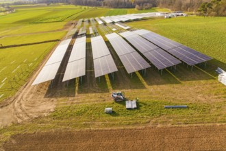 Aerial view of a solar installation site surrounded by green fields, energy revolution,