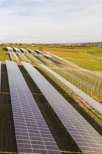 Numerous solar modules cover fields in rural countryside, energy transition, construction of PV