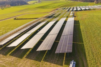 Aerial view of large solar systems on green fields in a rural landscape, energy transition,