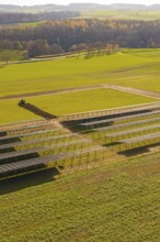 Incomplete solar park with empty structures and green land in autumn, energy revolution,