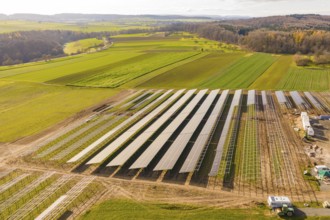 Solar panels on a field in a hilly landscape under sunny sky, Energiewende, construction of PV open