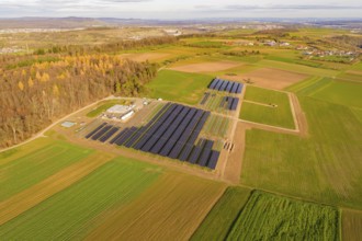 Aerial view of a solar field with autumn surroundings in a rural region, energy transition,