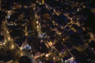 Drone image of an illuminated city at night with visible streets and alleys, Christmas market,
