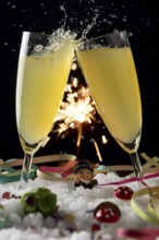 Two sparkling champagne glasses against a sparkling background in the snow with lucky New Year's