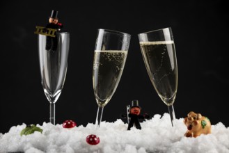 Champagne glasses filled with lucky charms for New Year in the snow