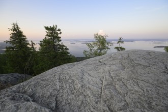 Tranquil view of a lake at dusk with rocks and trees in the foreground, Koliberg, Finland's most