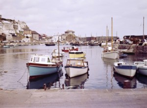 Boats at moorings in the harbour at seaside fishing village of Mevagissey, Cornwall, England, UK c